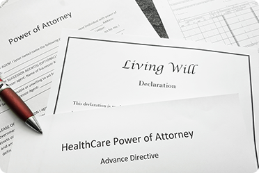 Close-up of legal documents: Living Will, Power of Attorney, HealthCare Power of Attorney. Pen included