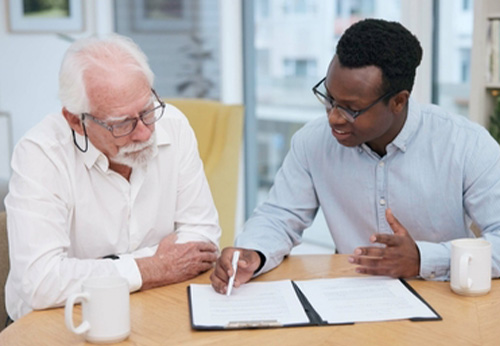 A person signing a document titled LAST WILL AND TESTAMENT on a clipboard.